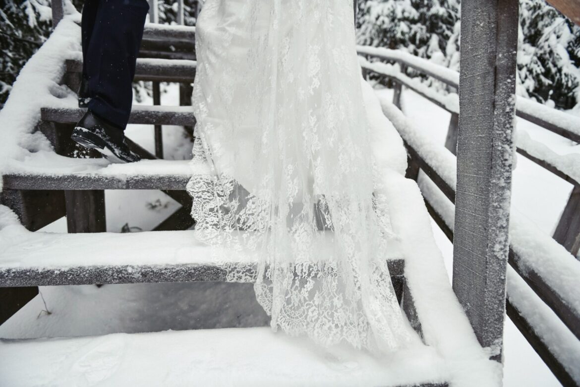 woman in a bridal dress and a man in a suite in winter, walking up stairs